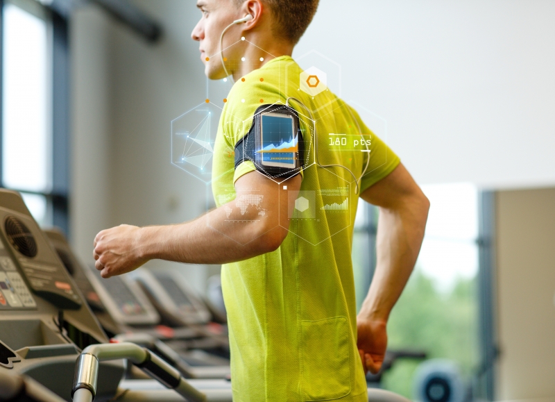 9894768-man-with-smartphone-exercising-on-treadmill-in-gym
